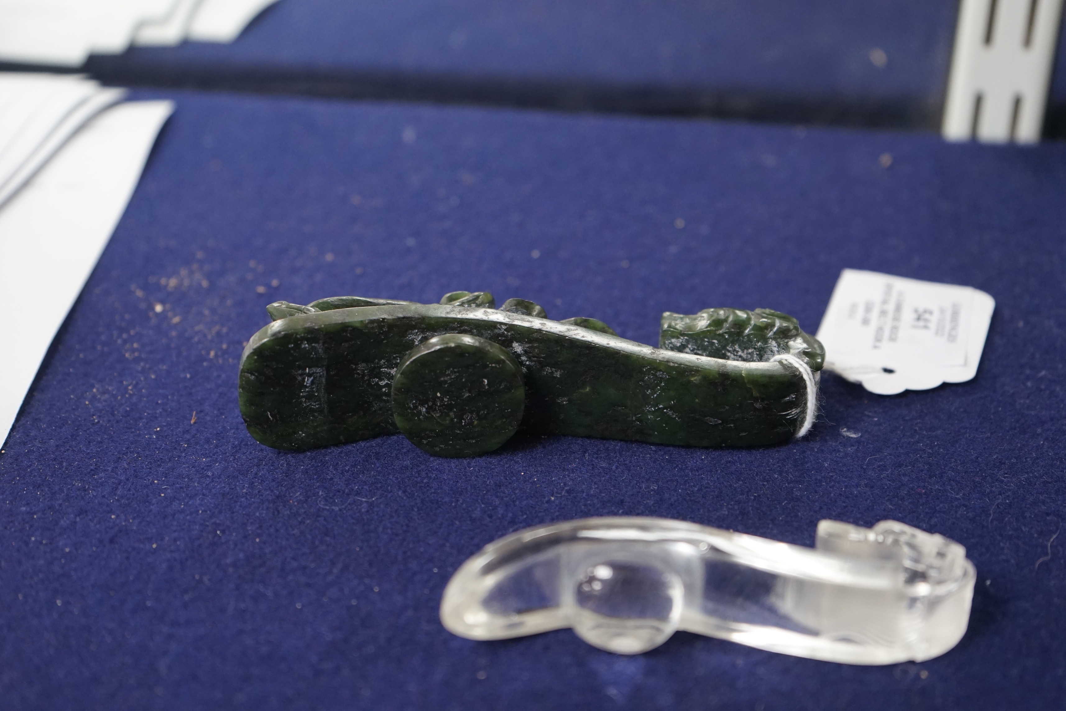 A Chinese rock crystal belt hook and a Chinese spinach green jade belt hook (2), largest 12cms long